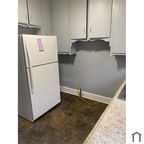 A white refrigerator with a pink sticker on it.