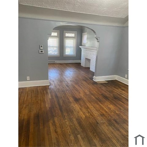 A room with wooden floors and a fireplace.