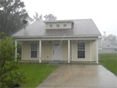 A small house with a porch and a covered walkway.