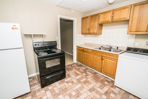A kitchen with a black stove top oven and a white dishwasher.
