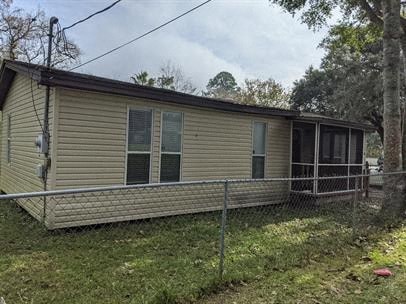 A beige mobile home with a porch and a fence.