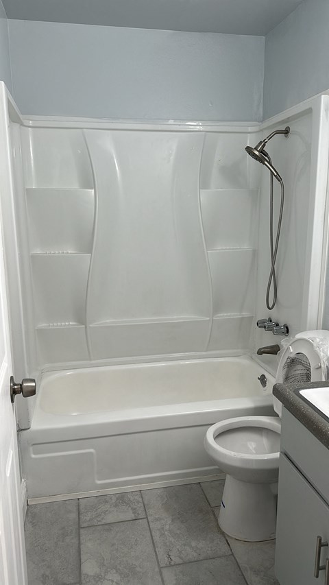 A white bathroom with a toilet and a bathtub.