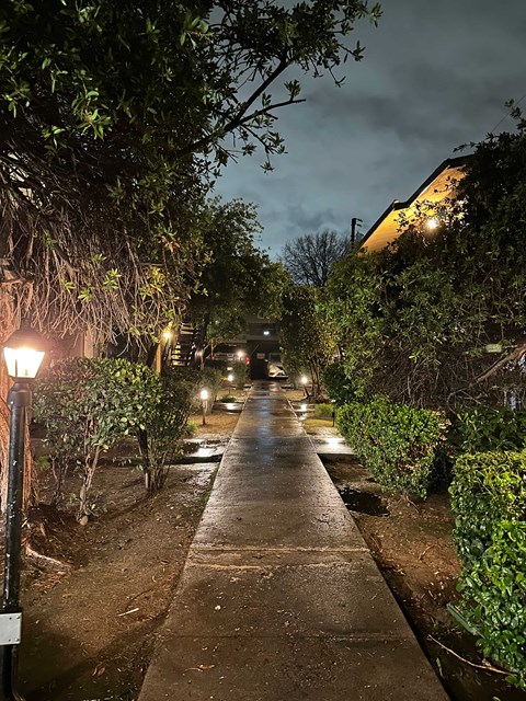 A street with a lamp post on the left and a building on the right.