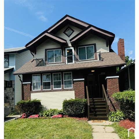 A house with a brown roof and a front porch with stairs.