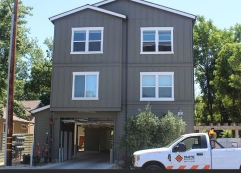 A two-story house with a white truck parked in front.