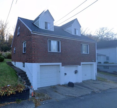 A red brick house with a white garage door.