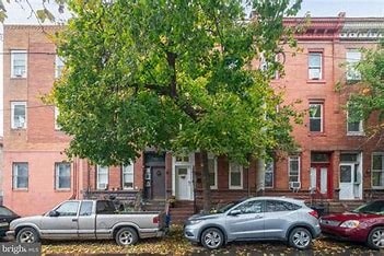 A tree in front of a red brick building.