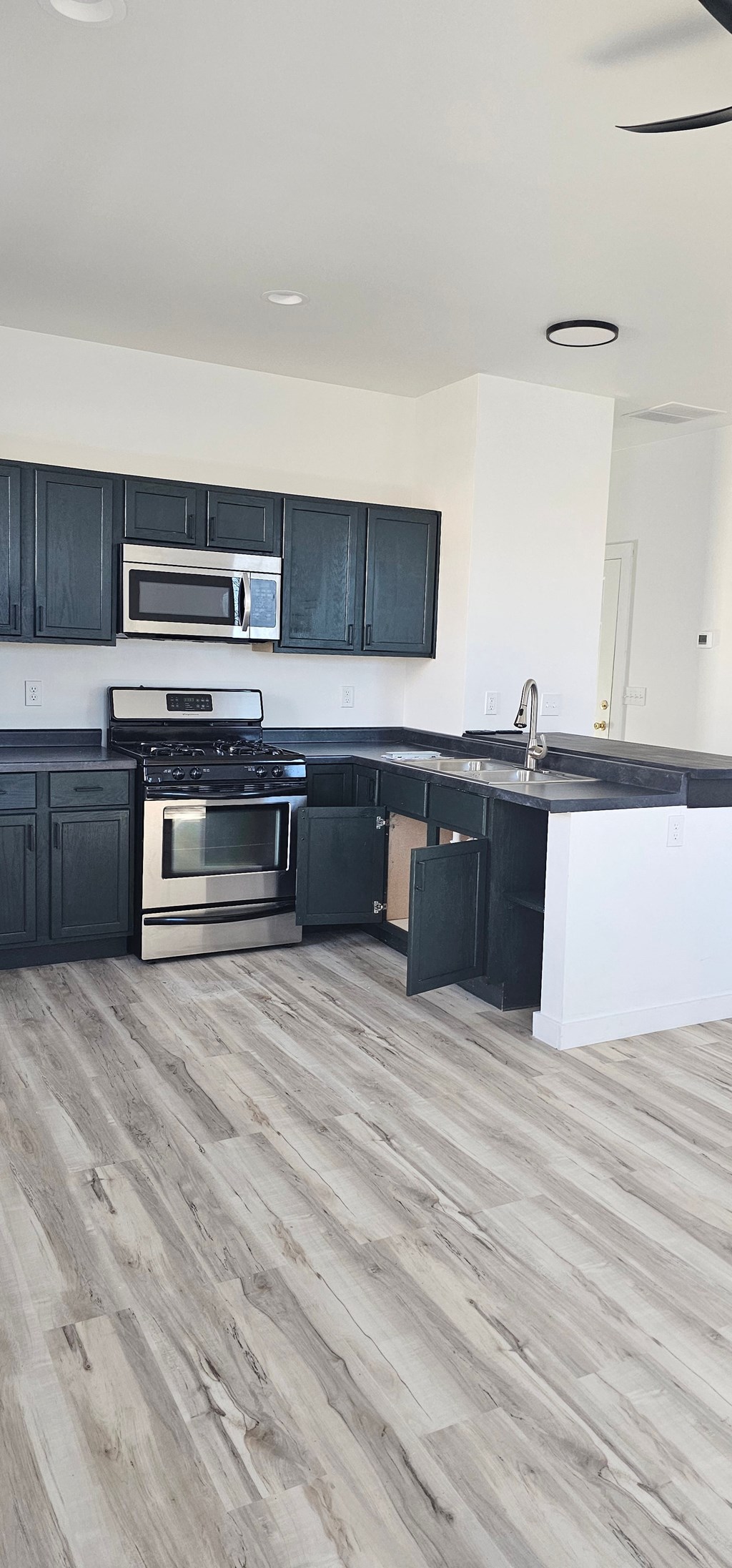 A kitchen with black cabinets and a white countertop.