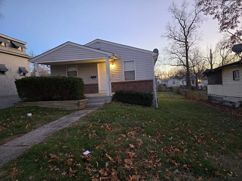 A house with a front yard and a pathway leading to the front door.
