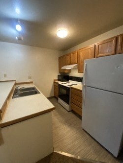 A kitchen with a white refrigerator and wooden cabinets.