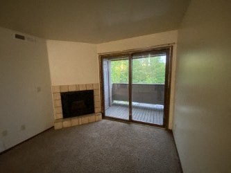 A room with a fireplace and sliding glass doors.