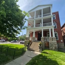 A red brick building with a white balcony.