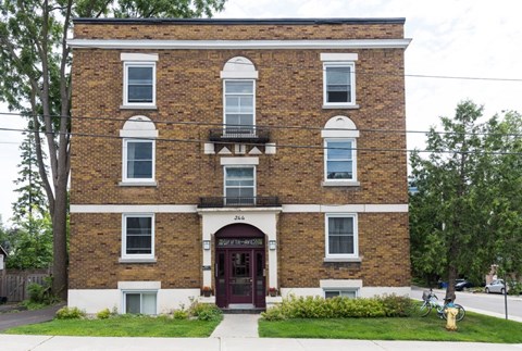 A brick building with a balcony on the second floor.
