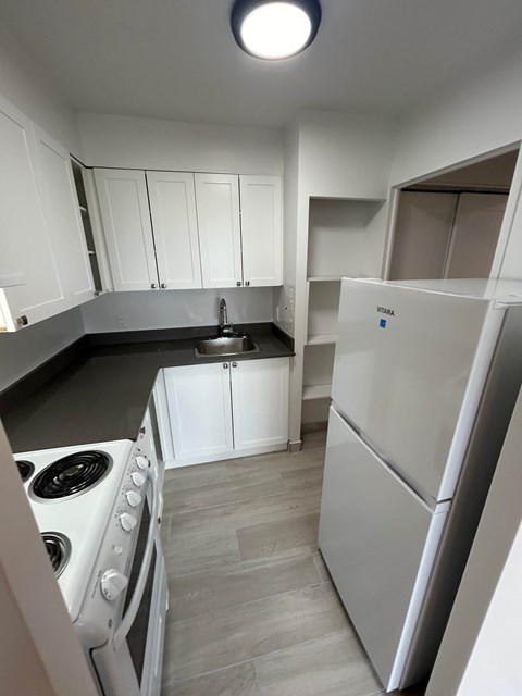 A kitchen with a white fridge and stove.