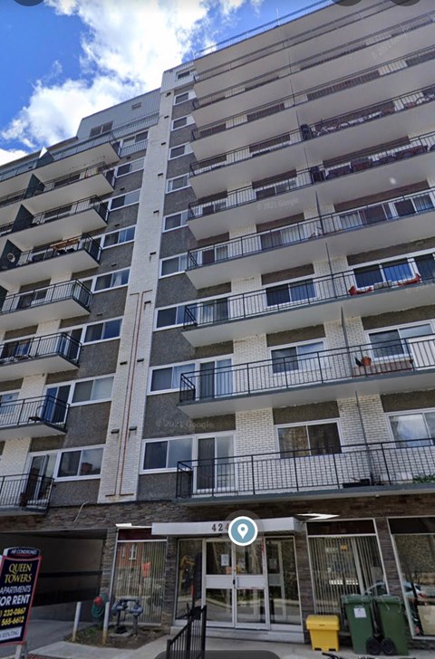 A tall residential building with balconies and a sign that reads "CLOSED".