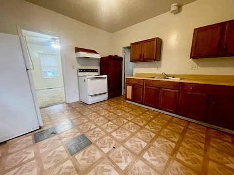 A kitchen with brown cabinets and a white fridge.