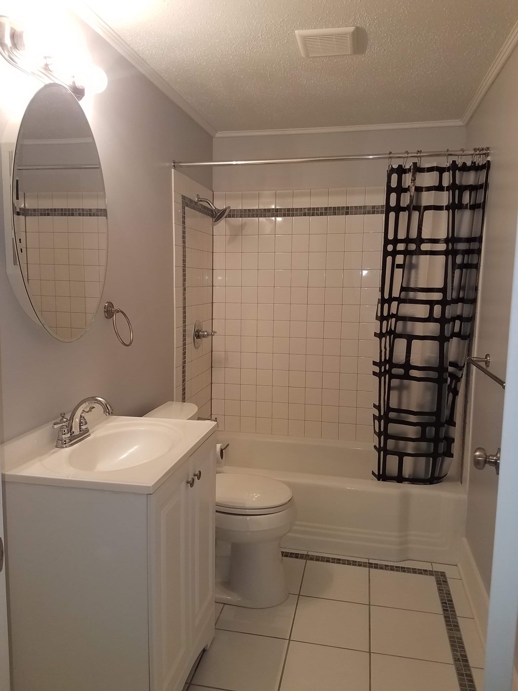 A white bathroom with a toilet, sink, and shower.