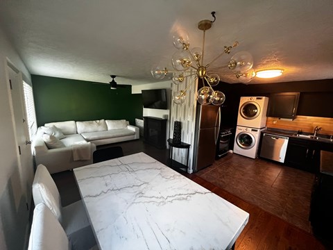 A living room with a white couch and a marble table.