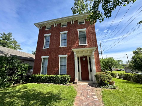 A red brick house with a white door and windows.