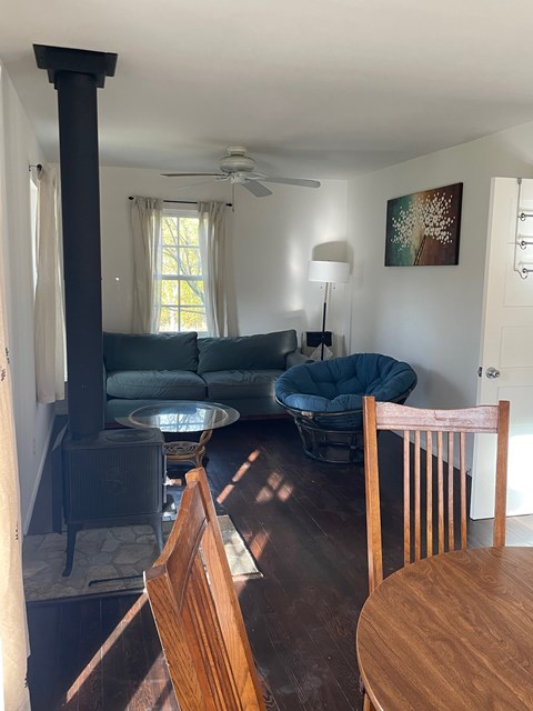 A living room with a wood stove and a blue chair.