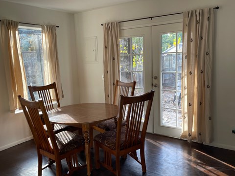 A dining room with a table and chairs.