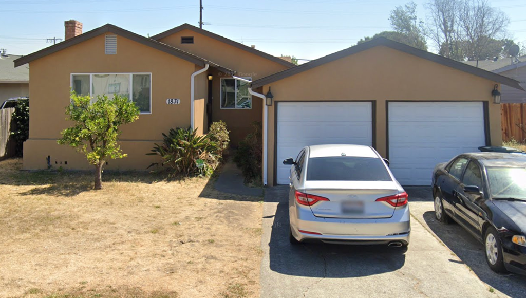 A house with a car parked in front of it.