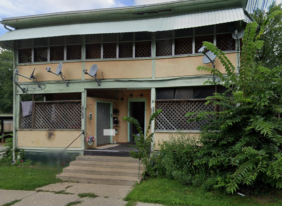 A building with a green roof and satellite dishes on the roof.