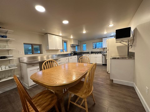 A kitchen with a wooden table and chairs.