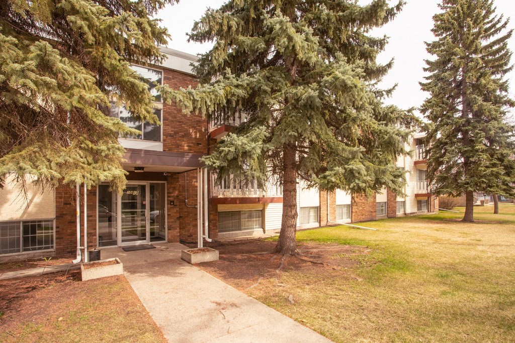 A building with a brick facade and a tree in front of it.