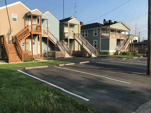 A row of houses with a road in front of them.