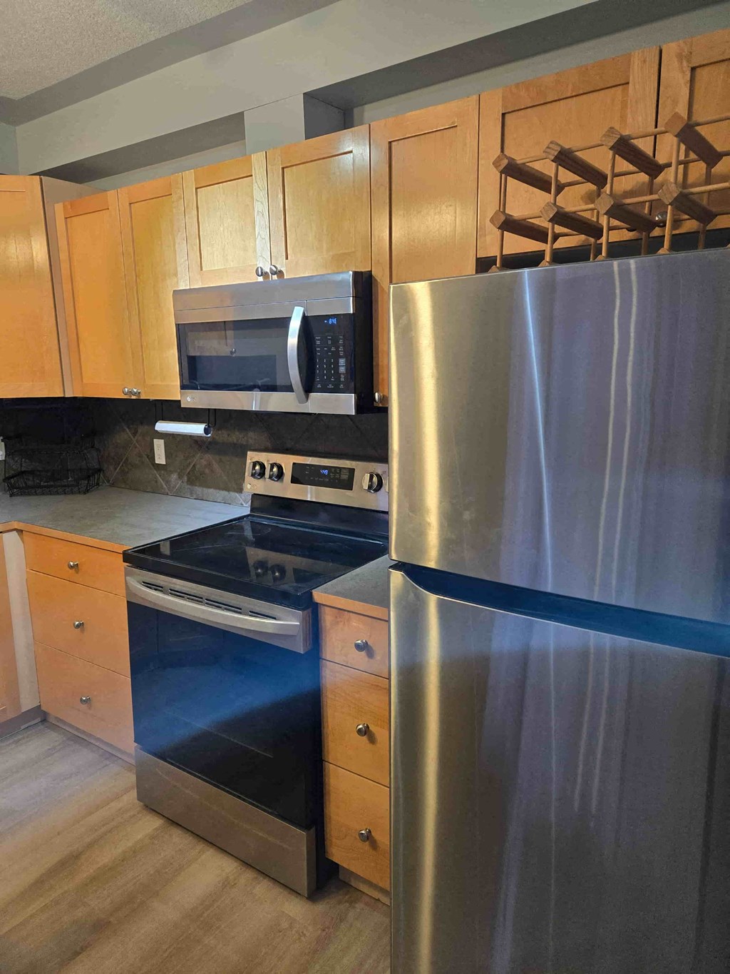 A kitchen with a stainless steel refrigerator, oven, and microwave.