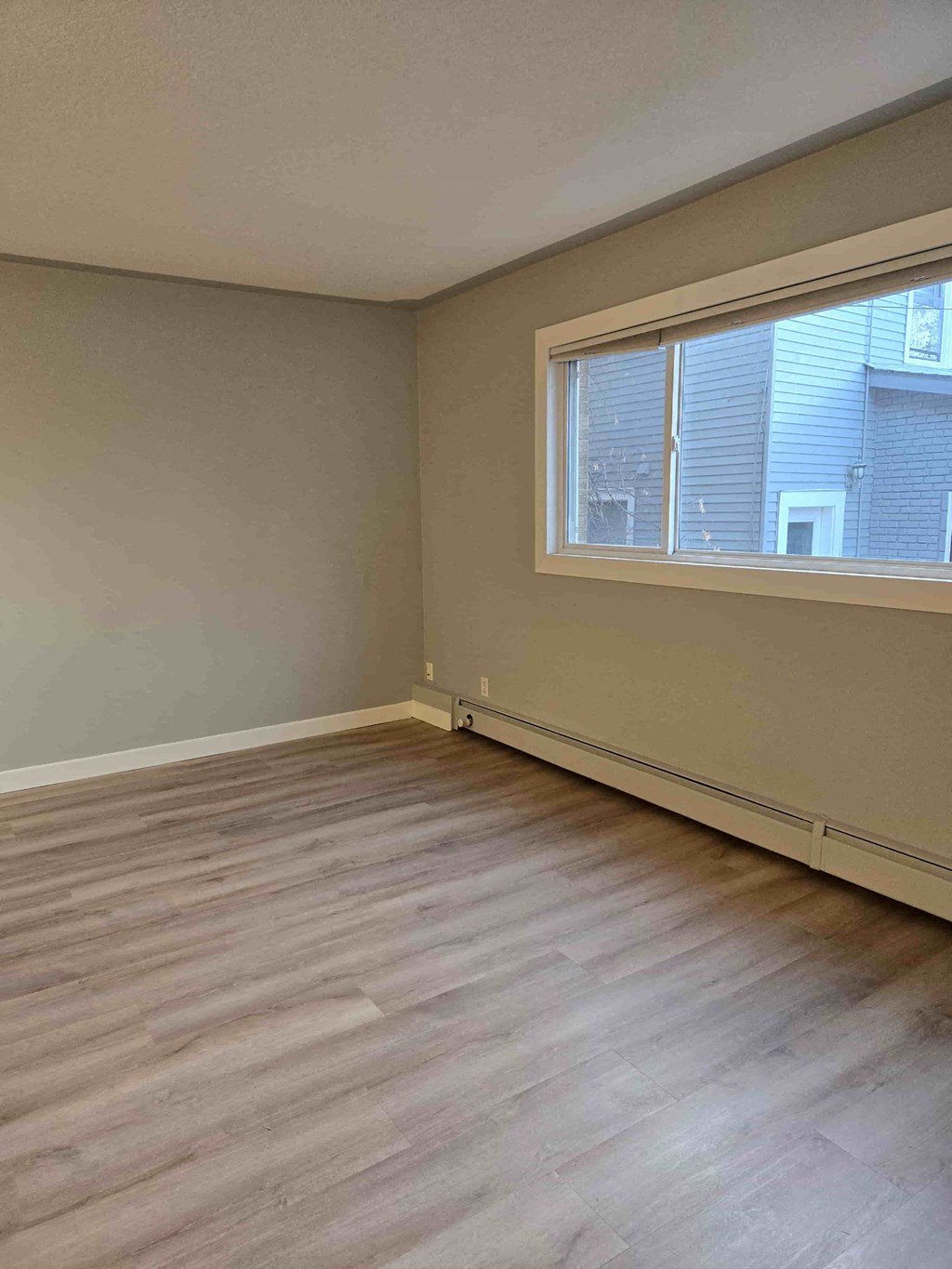 A room with a window and wooden flooring.