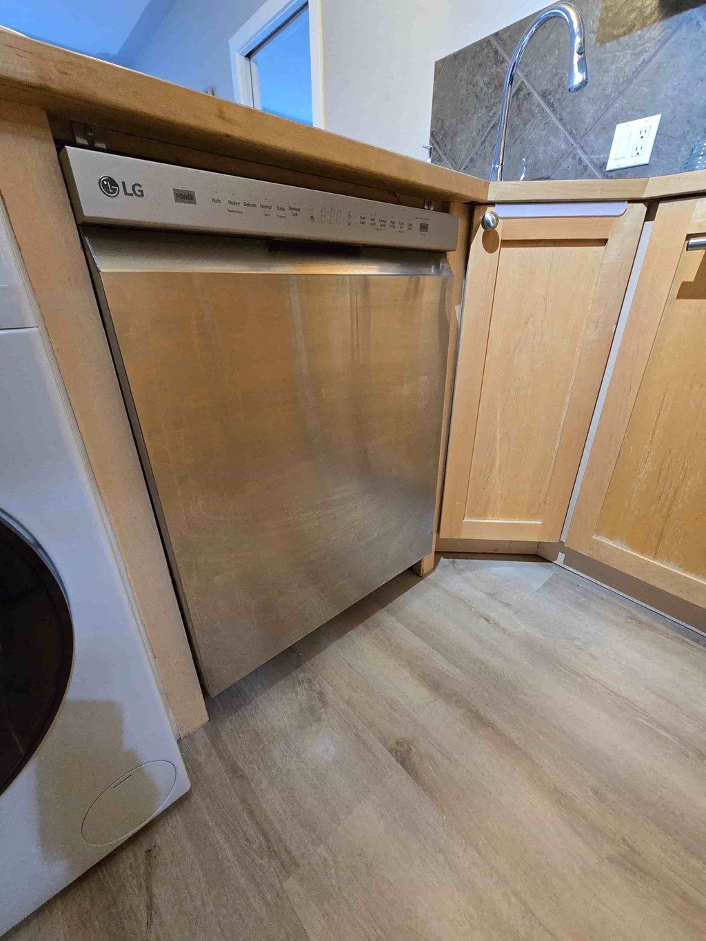 A modern kitchen with a dishwasher and a washing machine.