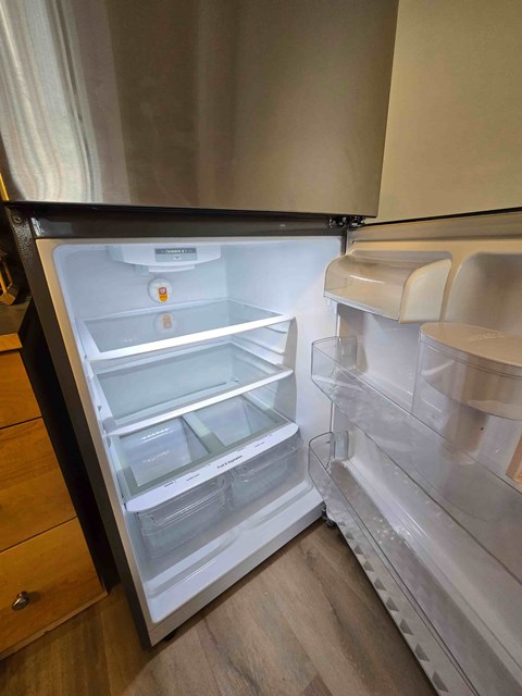 A white refrigerator with the door open is in a kitchen.