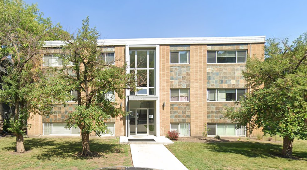 A building with a glass entrance and a brick facade.