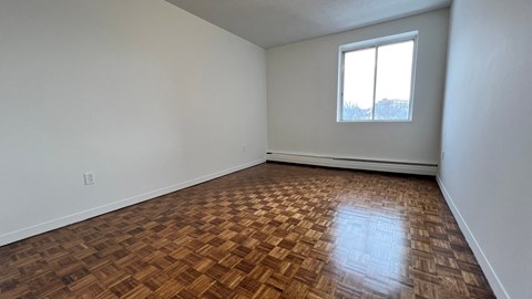 A room with a wooden floor and a window.