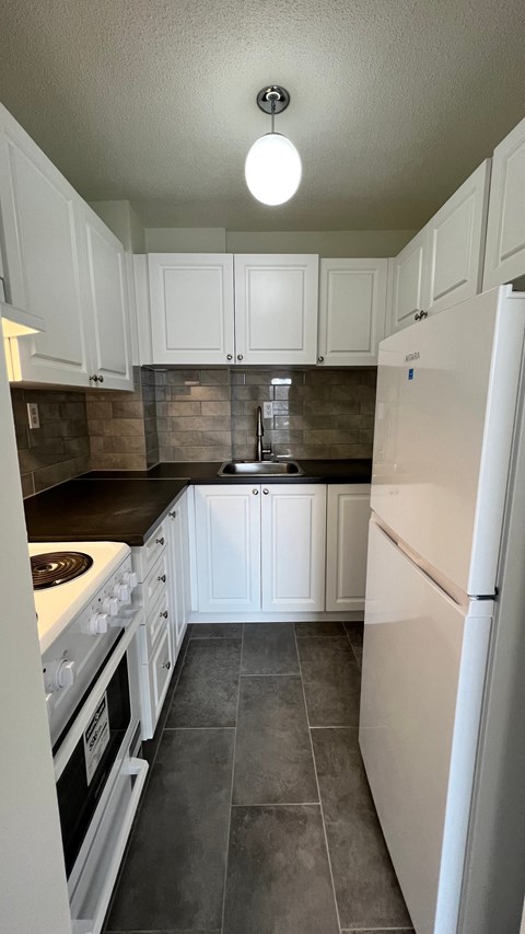 A kitchen with white appliances and cabinets.