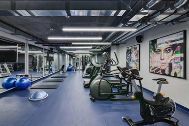 A gym with a row of exercise bikes and a blue exercise ball.