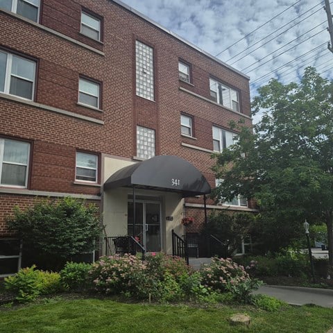 A brick building with a black awning and the number 341 on it.