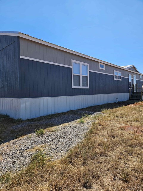A long building with a grey roof and white trim.