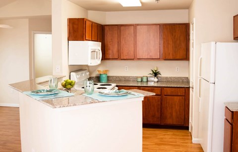 A kitchen with brown cabinets and a white fridge.