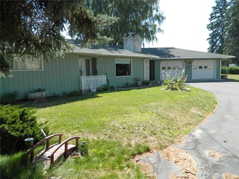 A house with a green exterior and a white fence.