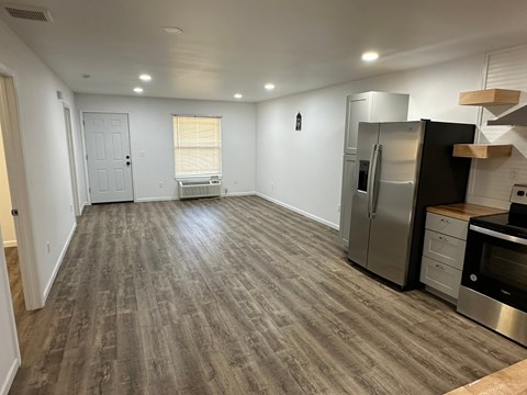 A kitchen with a refrigerator, oven, and sink.