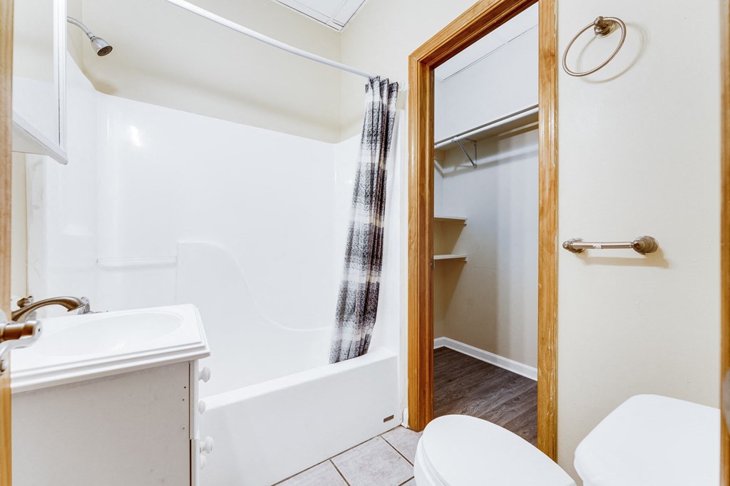 A white bathroom with a tub, toilet, and sink.