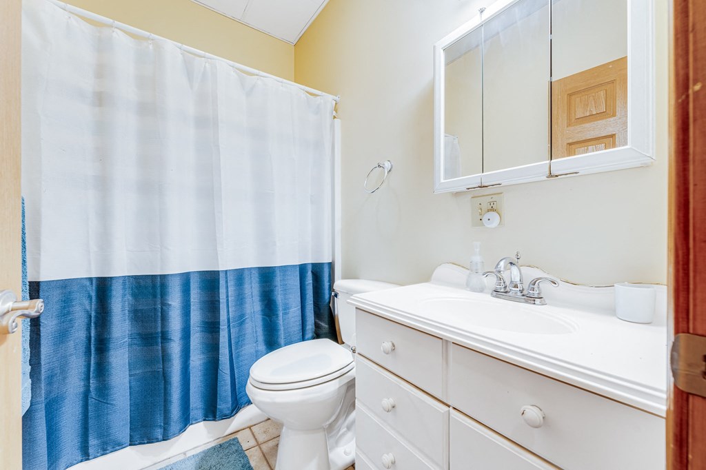 A white toilet sits next to a white sink in a bathroom.
