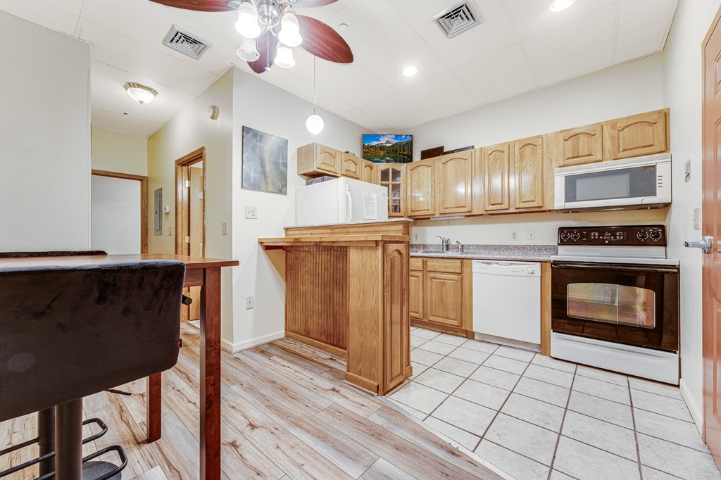 A kitchen with wooden cabinets and a white dishwasher.
