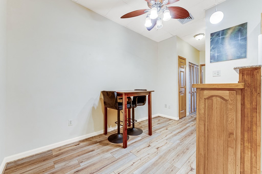 A room with a wooden floor and a table with chairs.
