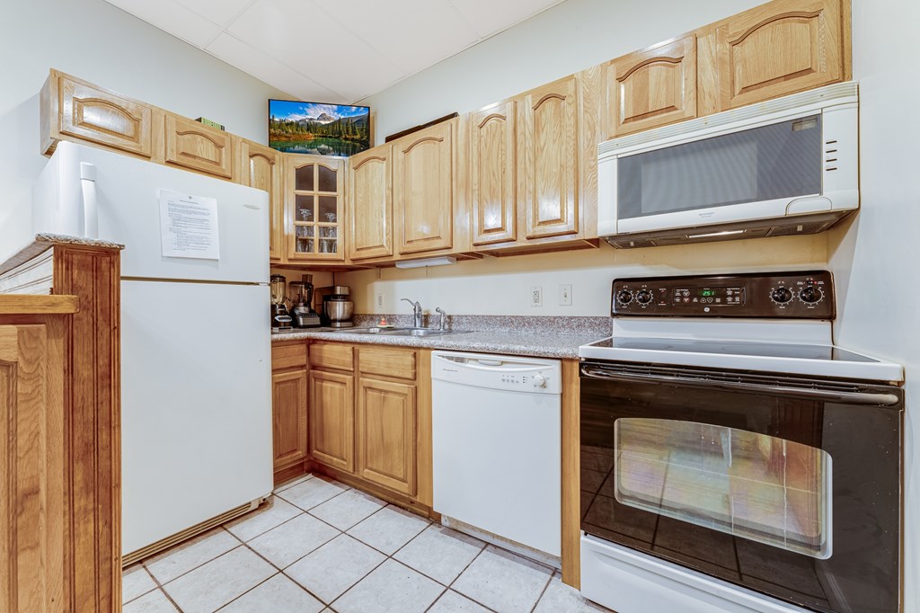A kitchen with wooden cabinets and white appliances.