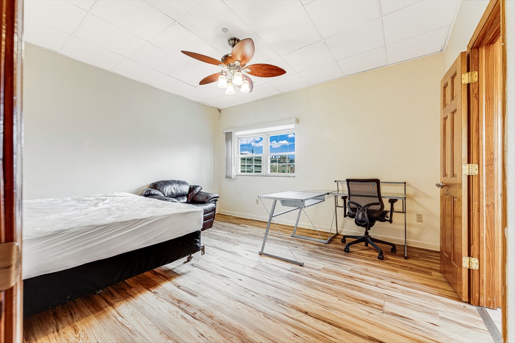 A bedroom with a bed, desk, and chair.