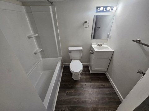 A white bathroom with a toilet, sink, and bathtub.